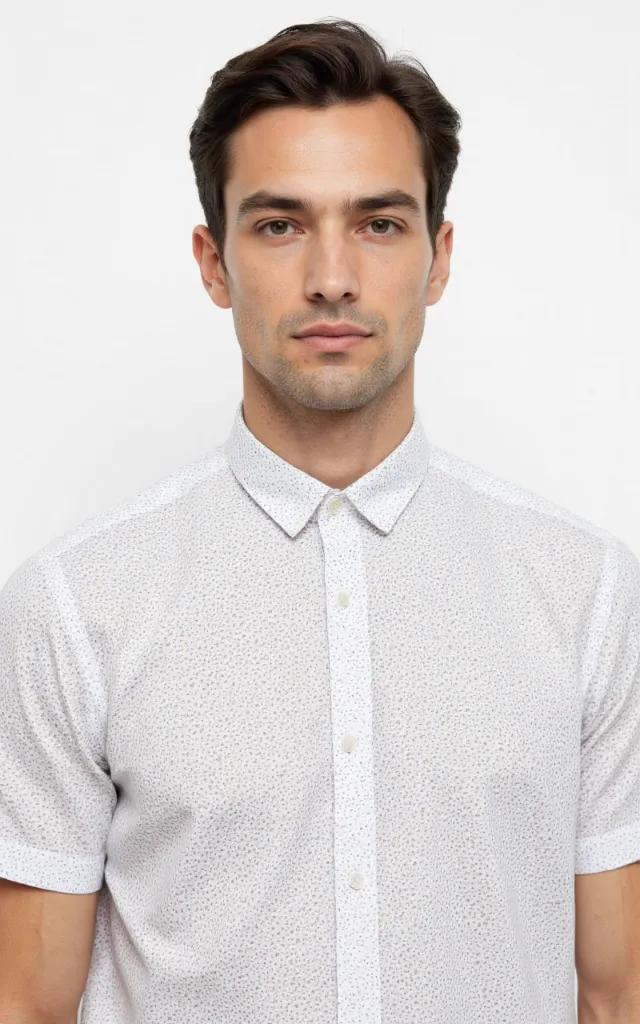A French model wearing a Speckled pattern   printed shirt, against a white background, in a front   facing bust portrait